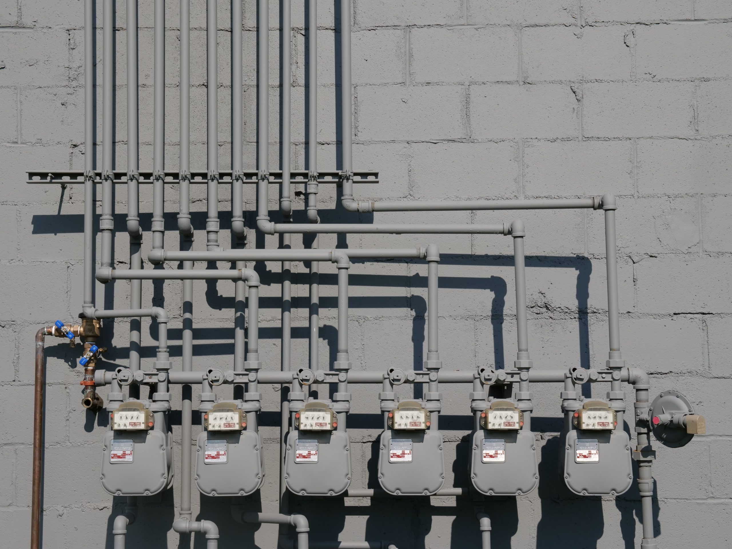 Compteurs gaz et tuyauterie sur mur béton