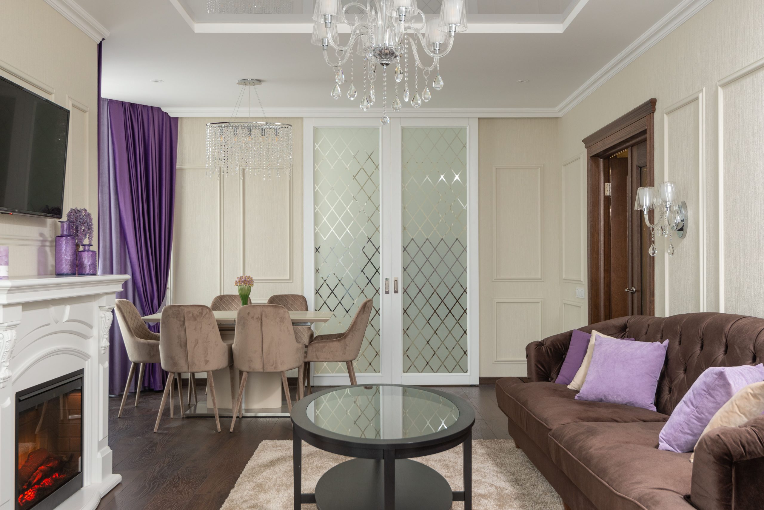 Salon moderne avec lustre, cheminée et accents violets