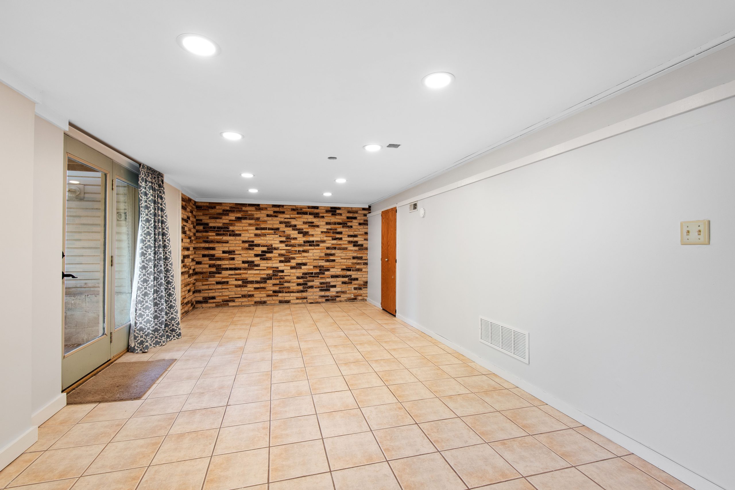 Sous-sol lumineux carrelage murs brique