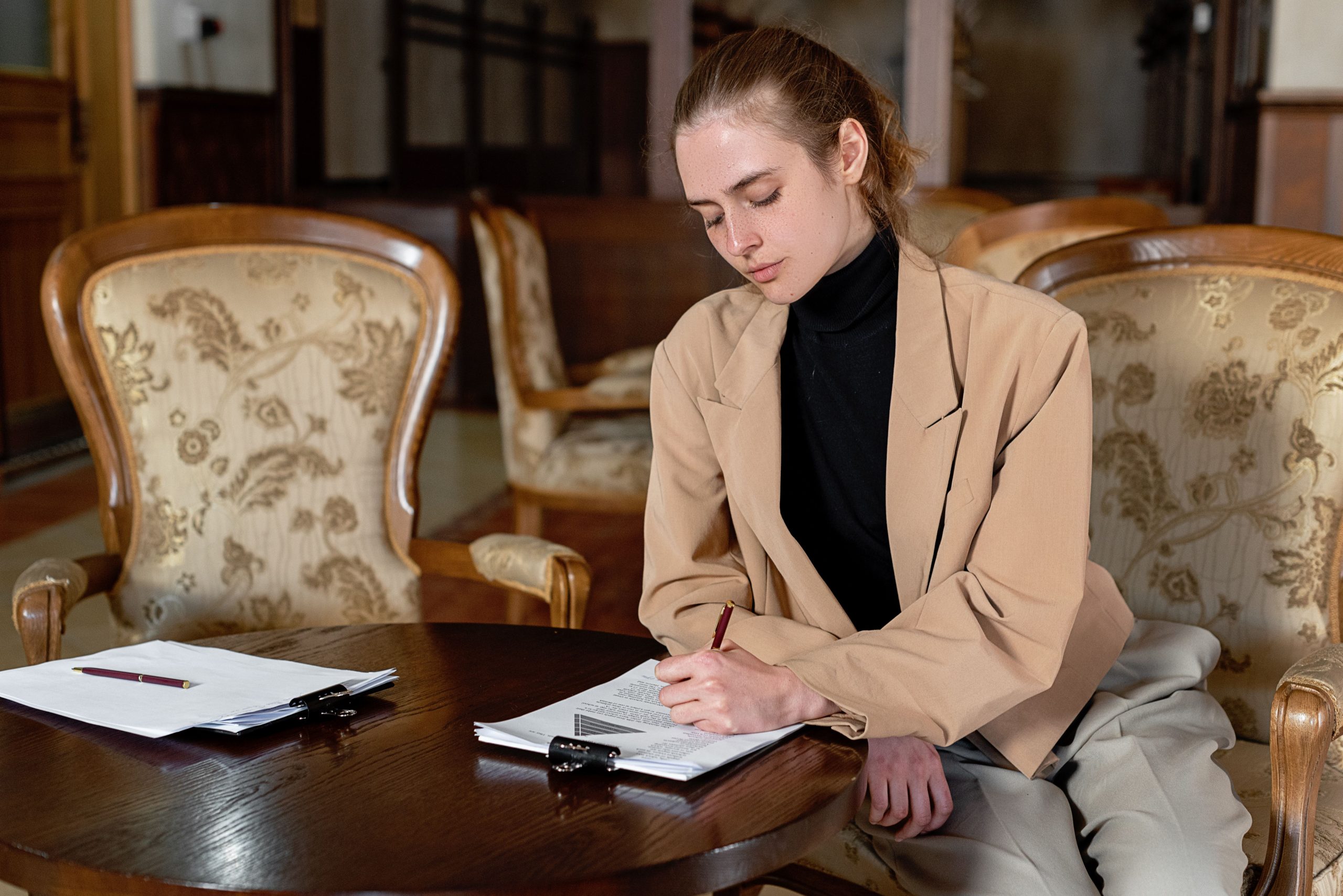 Jeune femme signant des documents dans un bureau