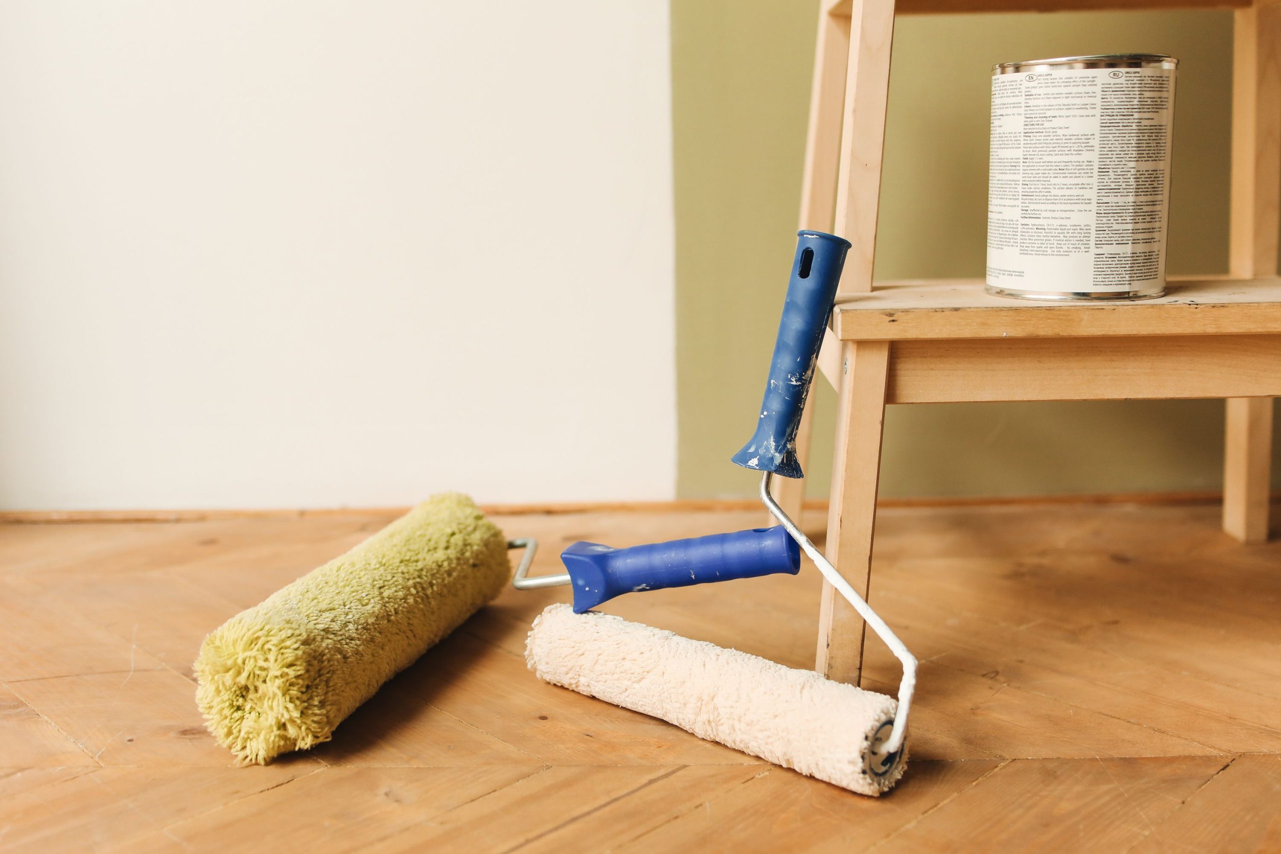 Rouleaux de peinture et pot sur plancher